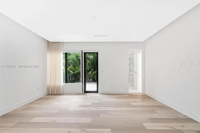 a view of an empty room with glass door and balcony