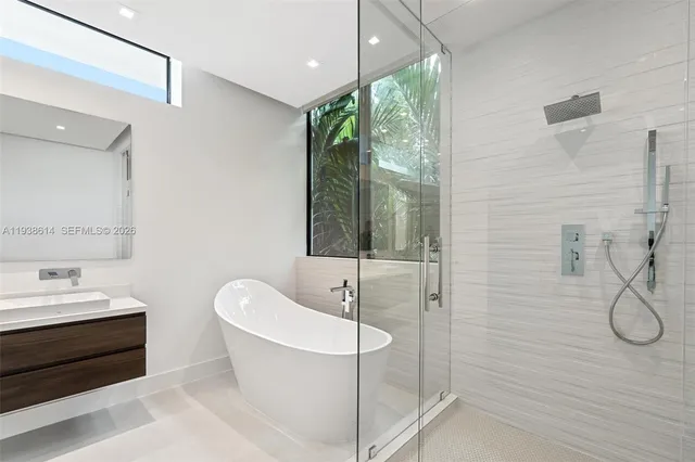 a bathroom with a white tub shower and sink