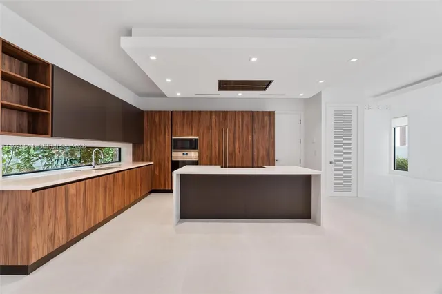 a large kitchen with stainless steel appliances a large counter top