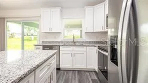 a kitchen with stainless steel appliances granite countertop a refrigerator sink and cabinets
