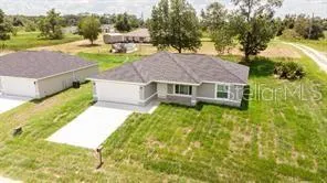 a aerial view of a house with swimming pool and green space