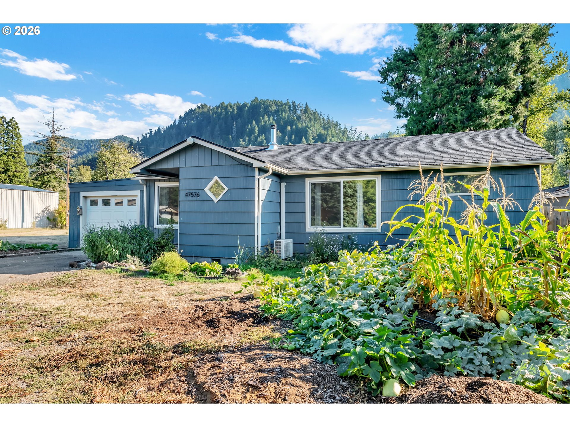 47576 Riverview Street Oakridge, OR 97463 - Photo 3 of 48 a view of a house with a flower garden