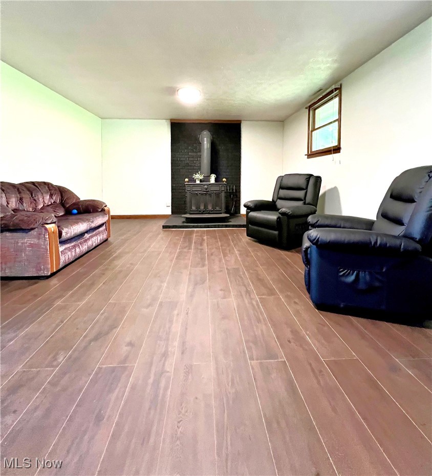 6443 Bloomfield Road Cambridge, OH 43725 - Photo 12 of 30 Family room with a wood stove and wood-type flooring.