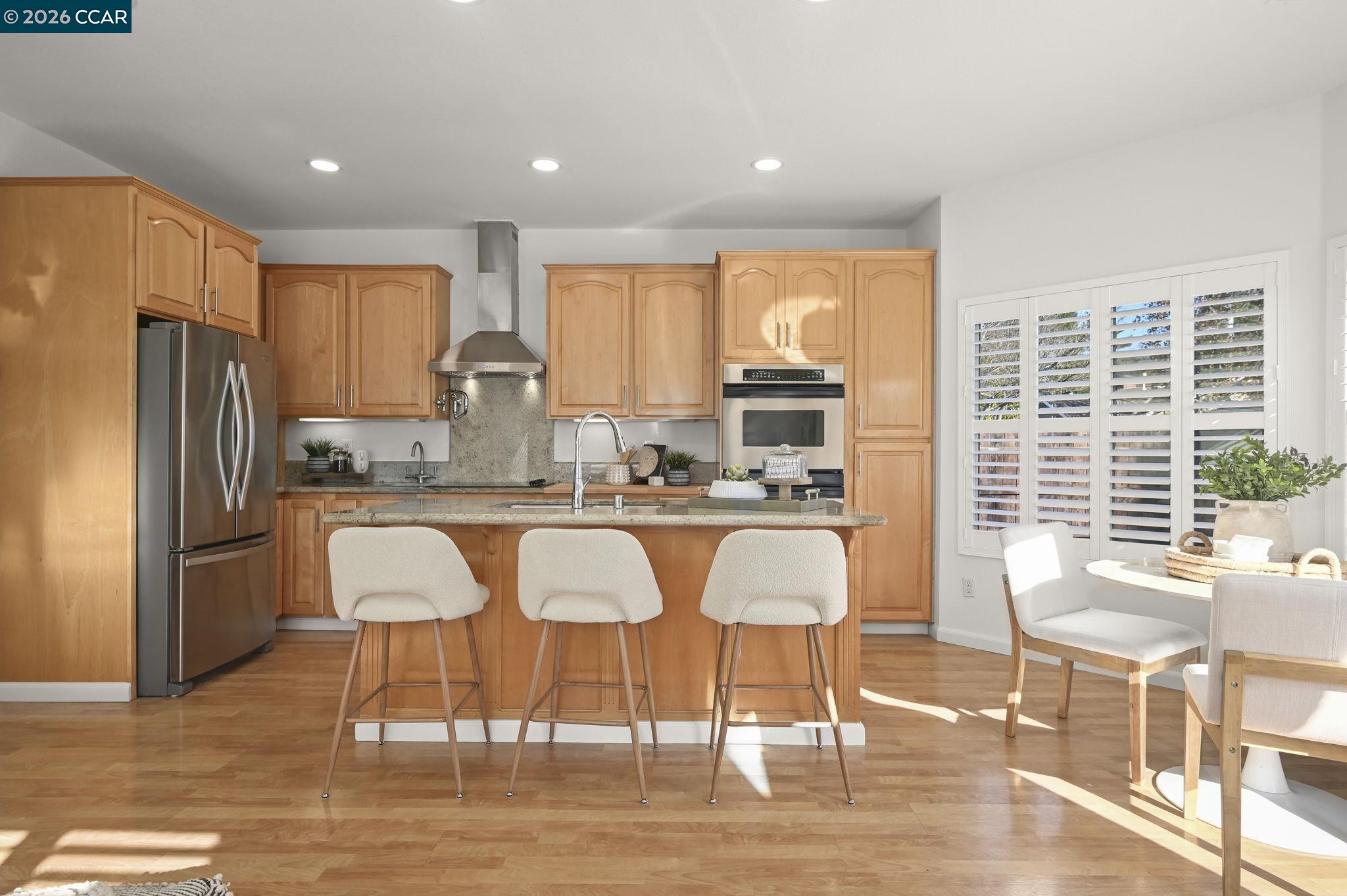 118 Neptune Place San Ramon, CA 94583 - Photo 10 of 36 a kitchen with stainless steel appliances granite countertop a table and chairs in it