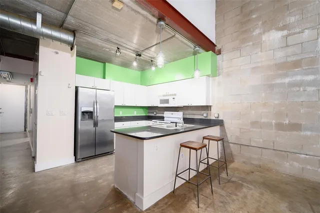 a kitchen with a stove a sink and white cabinets