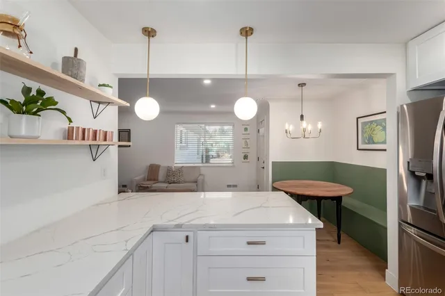 a kitchen with a refrigerator a sink and a wooden floors