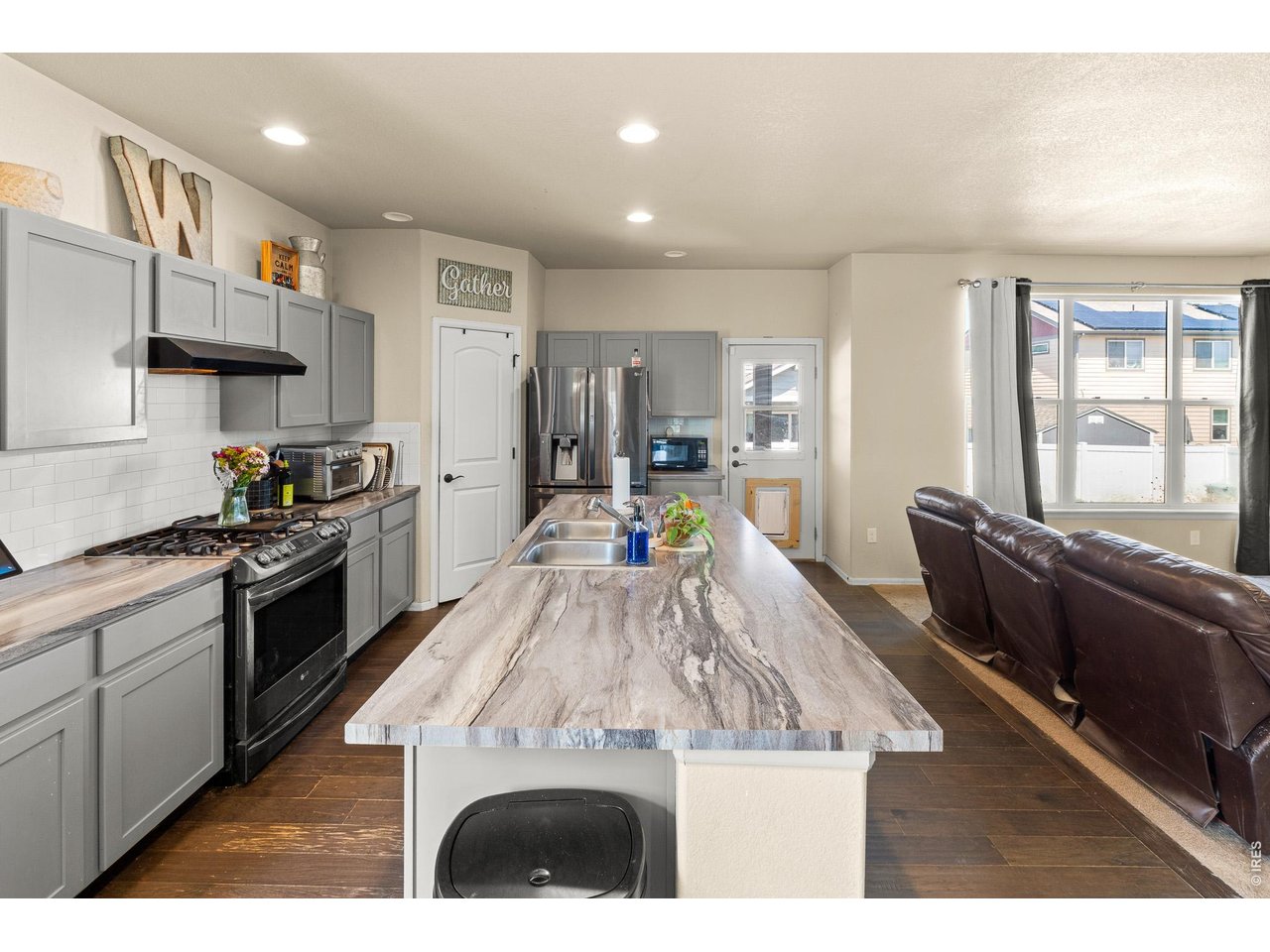 8847 16th St Road Greeley, CO 80634 - Photo 14 of 38 a kitchen with stainless steel appliances kitchen island granite countertop a refrigerator a stove top oven and a sink