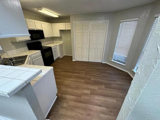 a kitchen with a refrigerator and a stove top oven