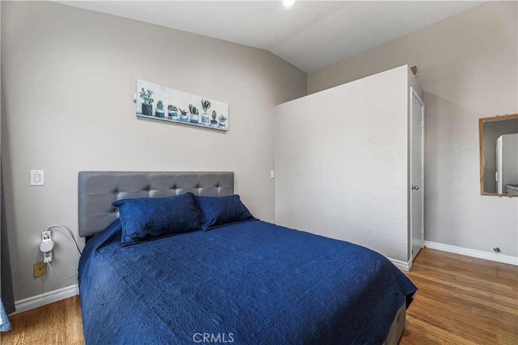 3512 West Stonepine Lane, Unit D Anaheim, CA 92804 - Photo 13 of 38 a bedroom with a bed and wooden floor