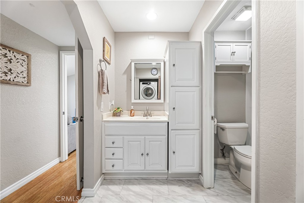 3512 West Stonepine Lane, Unit D Anaheim, CA 92804 - Photo 17 of 38 a bathroom with a sink a toilet and a mirror