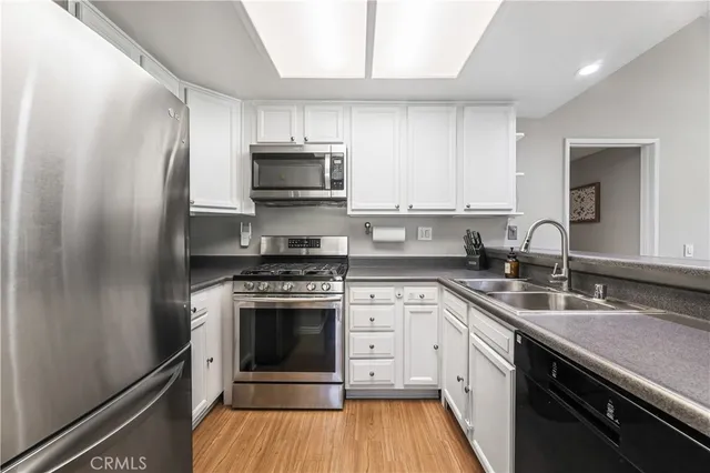 a kitchen with a sink cabinets and wooden floor