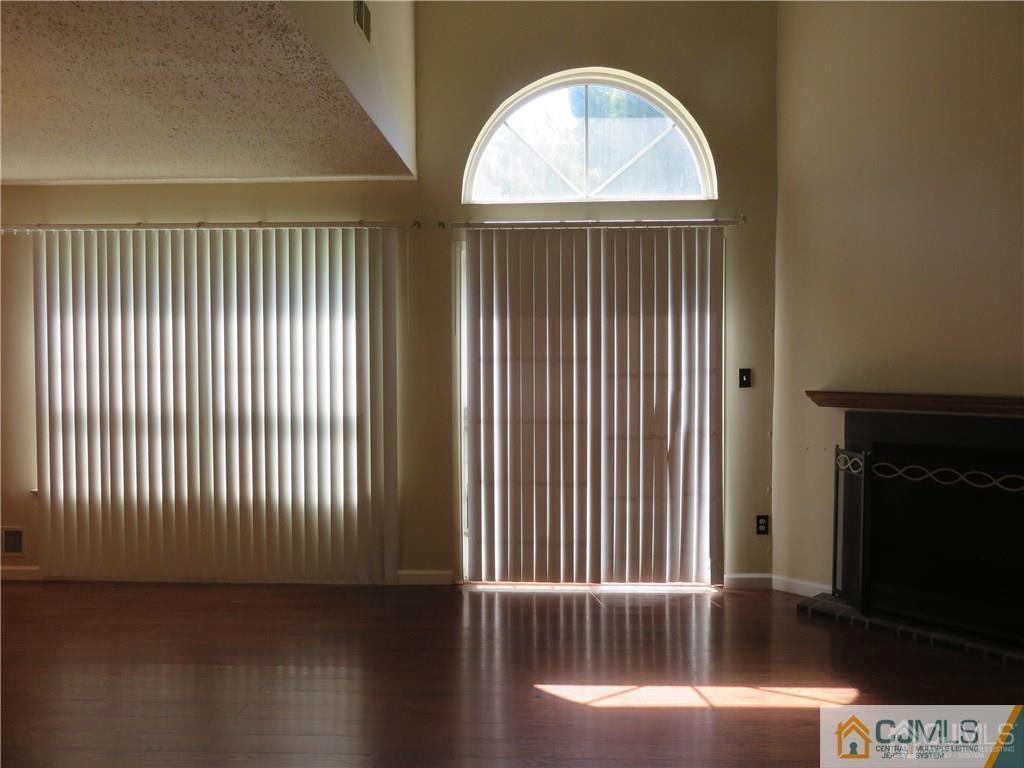 387 Draco Road, Unit 387 Piscataway, NJ 08854 - Photo 6 of 17 an empty room with wooden floor fan and windows