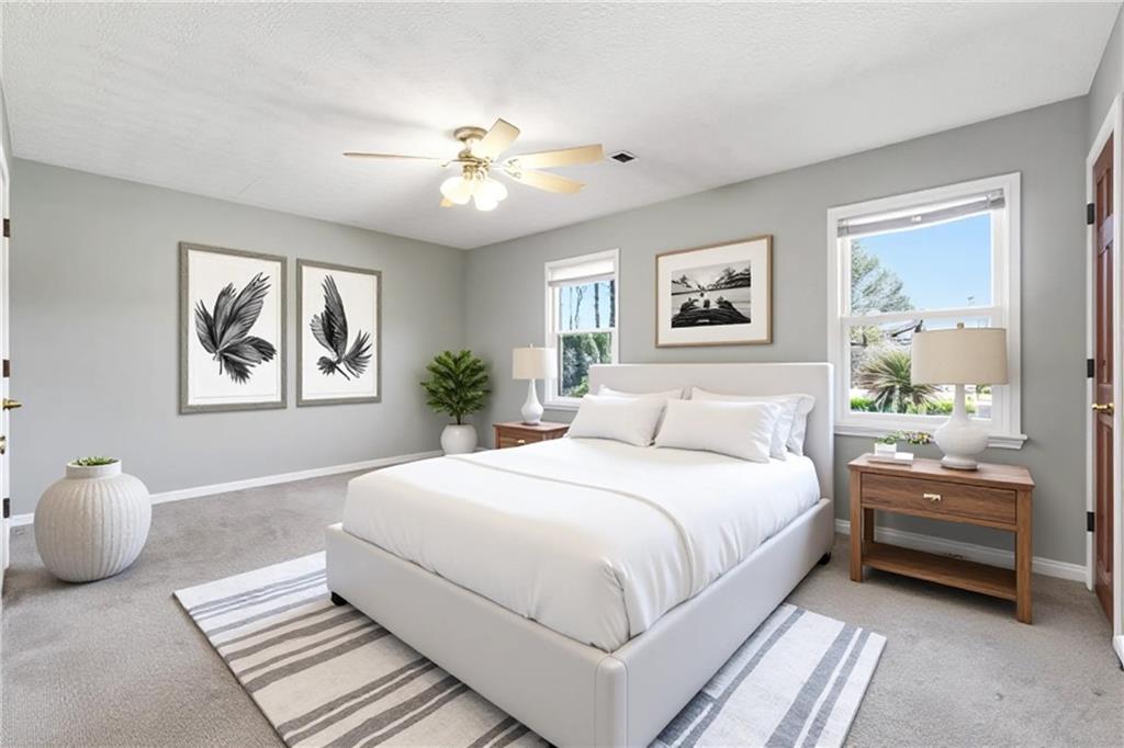 6148 Winfield Court Tucker, GA 30084 - Photo 16 of 27 a bedroom with a large bed and a chandelier