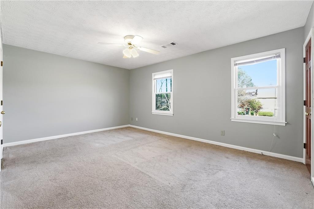 6148 Winfield Court Tucker, GA 30084 - Photo 17 of 27 an empty room with windows and chandelier fan