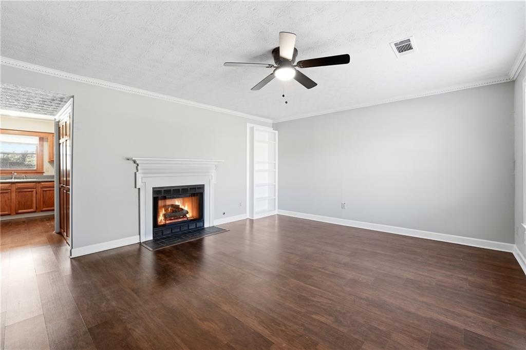 6148 Winfield Court Tucker, GA 30084 - Photo 2 of 27 an empty room with wooden floor fireplace and windows