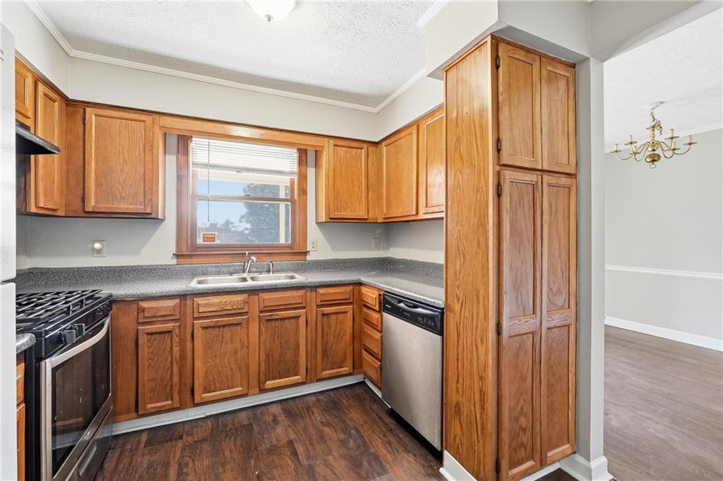 6148 Winfield Court Tucker, GA 30084 - Photo 7 of 27 a kitchen with stainless steel appliances granite countertop a sink a stove cabinets and wooden floor