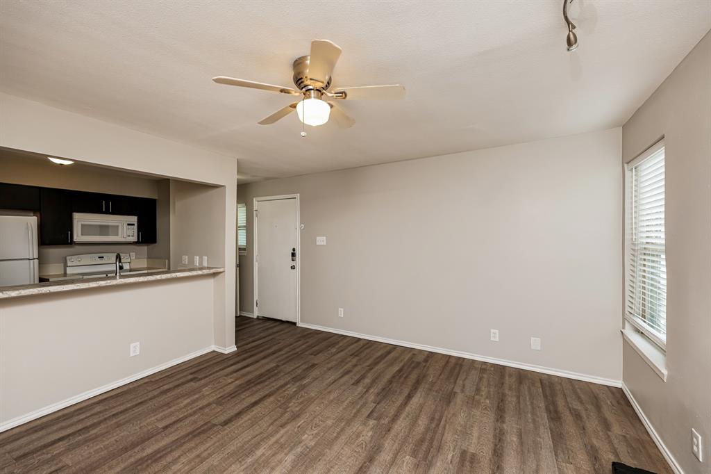 4622 Monarch Street, Unit 202 Dallas, TX 75204 - Photo 5 of 16 Open-concept living area featuring wood-finish flooring, a ceiling fan with light fixture, and a window with blinds
