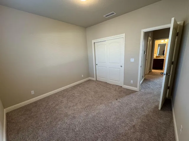 an empty room with a hallway and closet