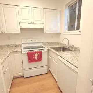 a utility room with stainless steel appliances granite countertop a sink and dishwasher