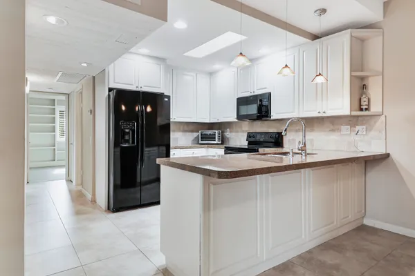 a kitchen with stainless steel appliances granite countertop a refrigerator and a stove