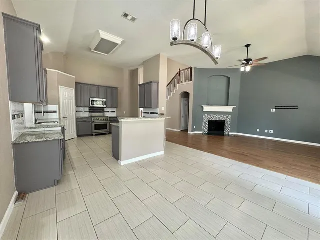a kitchen with stainless steel appliances granite countertop a refrigerator a stove top oven a sink dishwasher and white cabinets