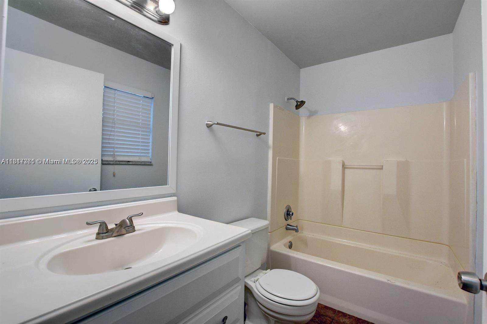28 Crossings Circle, Unit E Boynton Beach, FL 33435 - Photo 3 of 18 a bathroom with a bathtub shower sink vanity mirror and toilet