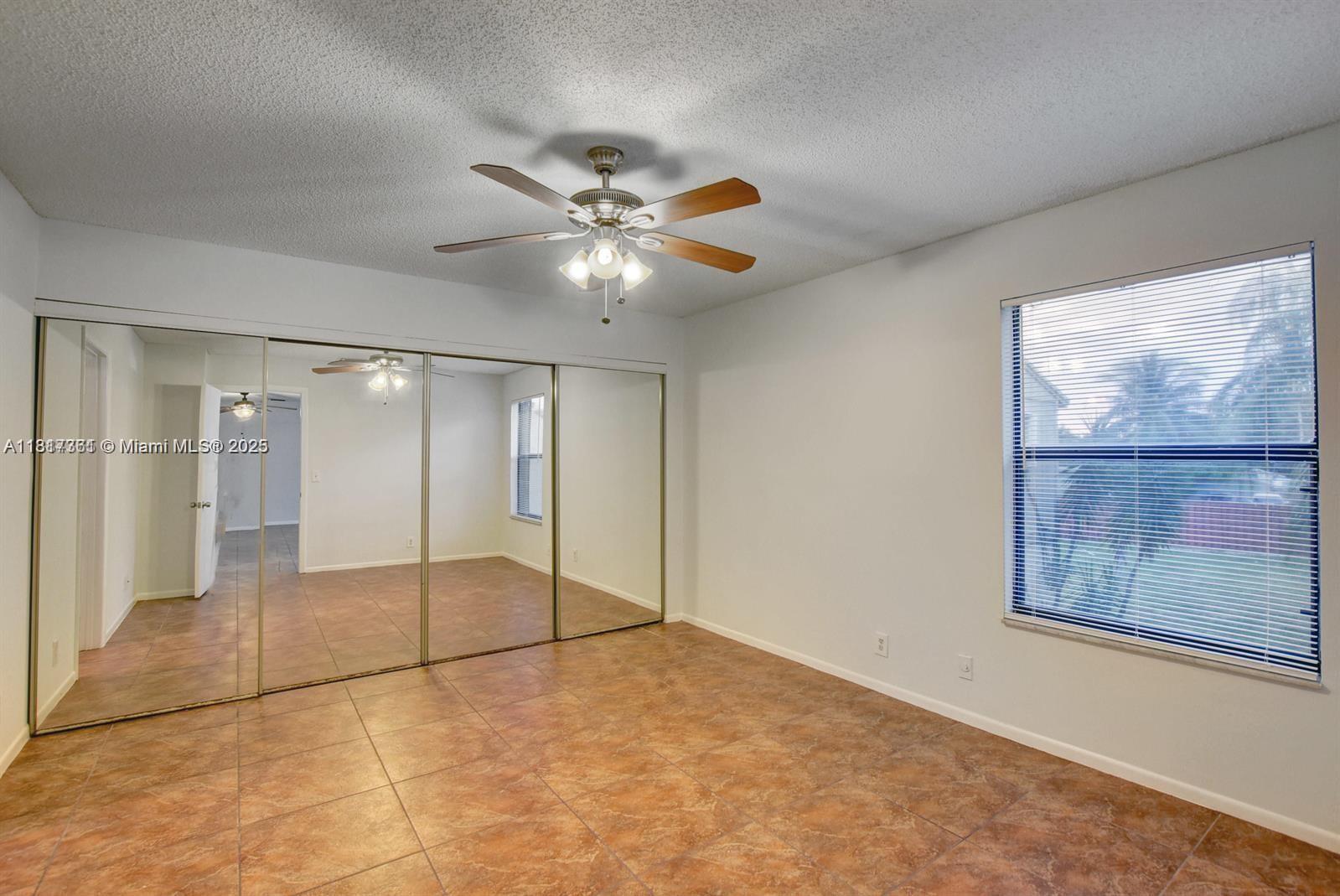 28 Crossings Circle, Unit E Boynton Beach, FL 33435 - Photo 7 of 18 an empty room with fan and windows