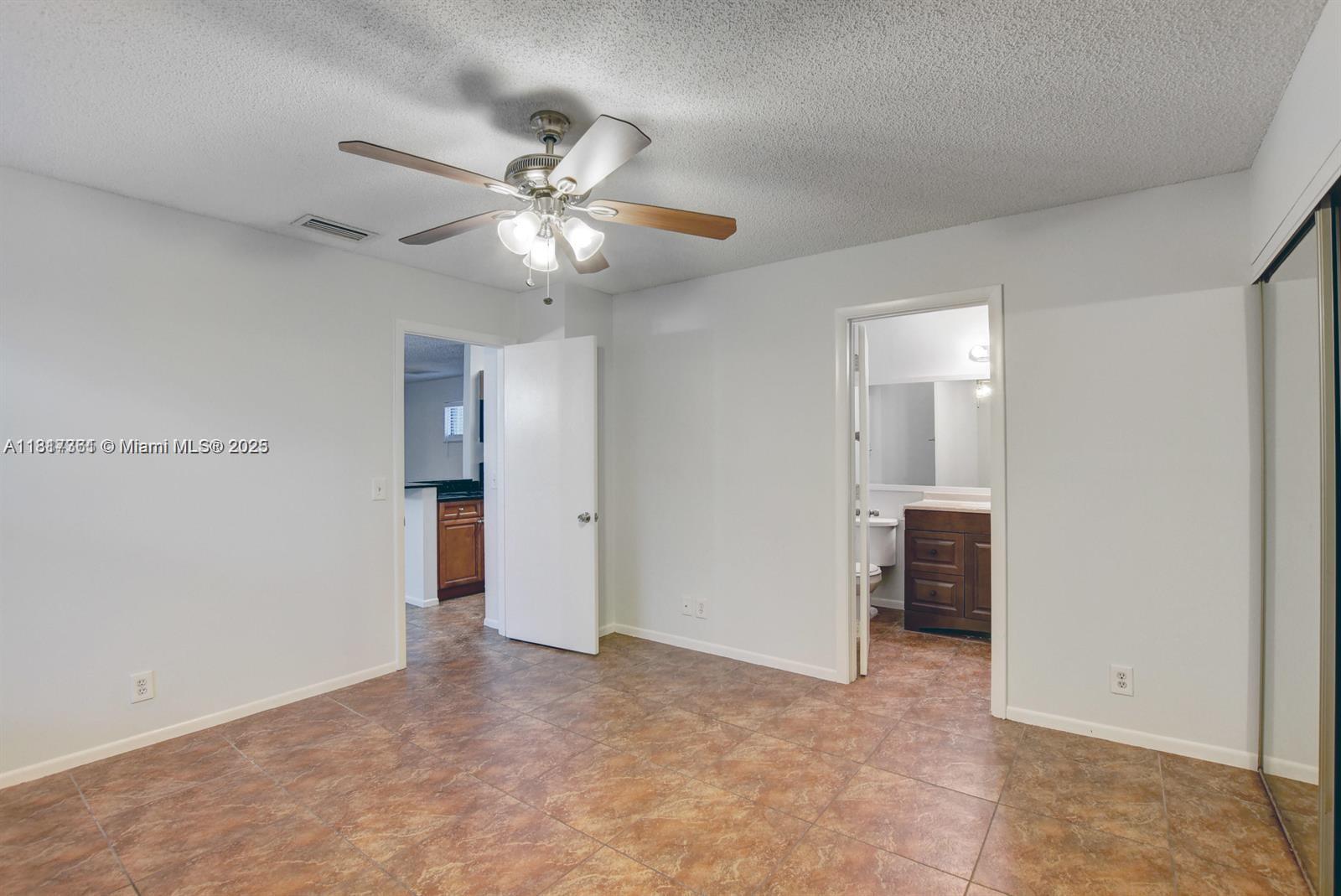 28 Crossings Circle, Unit E Boynton Beach, FL 33435 - Photo 8 of 18 a view of an empty room and chandelier fan