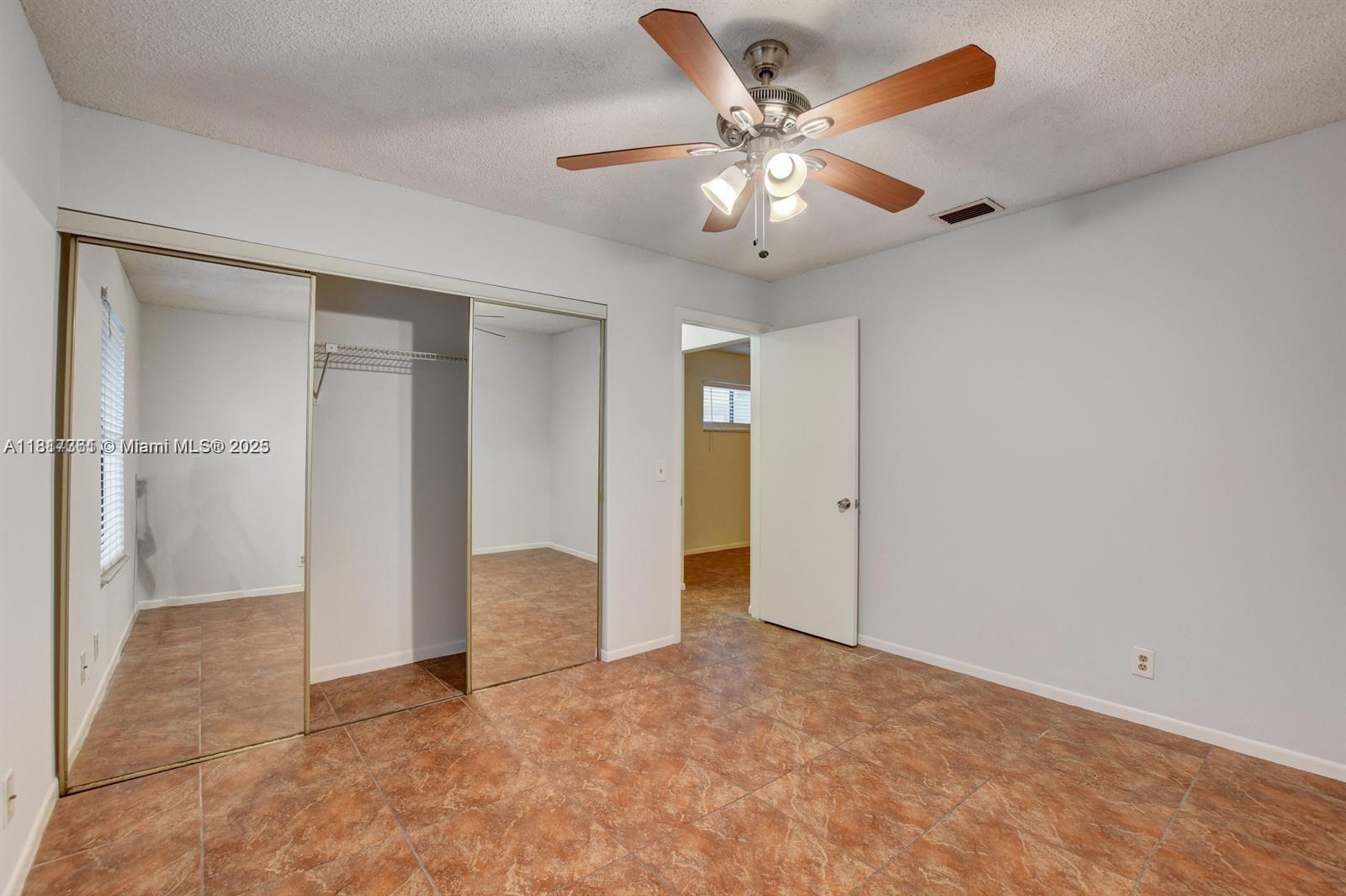 28 Crossings Circle, Unit E Boynton Beach, FL 33435 - Photo 10 of 18 an empty room with fan and entrance