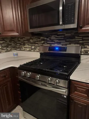 a stove top oven sitting inside of a kitchen