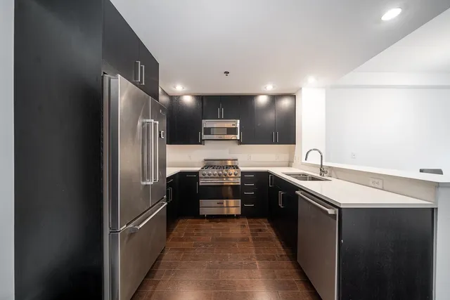 a kitchen with stainless steel appliances granite countertop a refrigerator and a sink