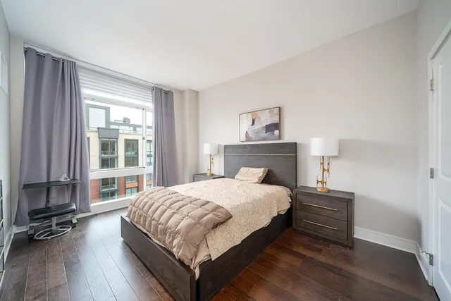 a bedroom with a bed and a large window