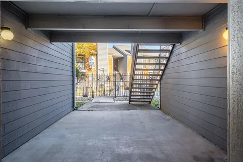 a view of a house with a small yard and wooden fence and large tree