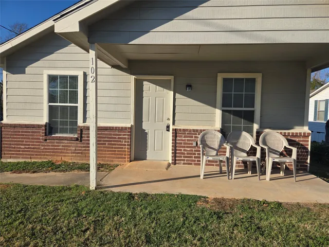 a view of a house with backyard and porch