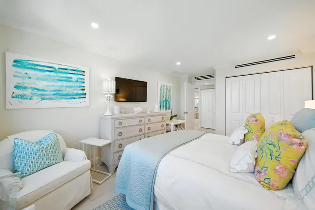 a bedroom with a bed a couch and a flat screen tv