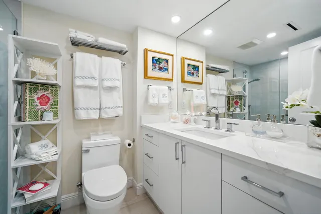 a bathroom with a toilet a sink and a large mirror