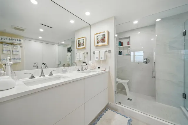 a bathroom with a double vanity sink mirror and shower