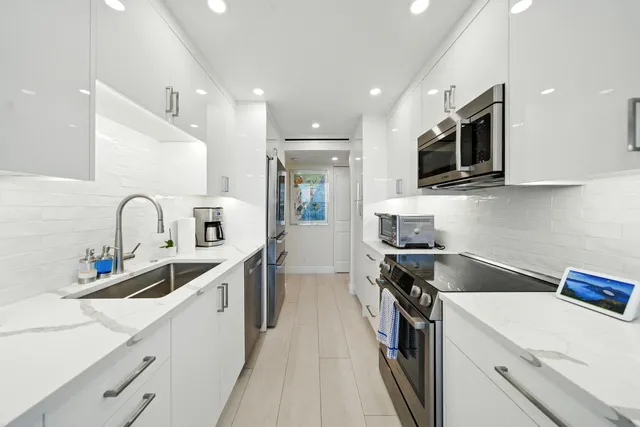 a kitchen with a sink stainless steel appliances and cabinets