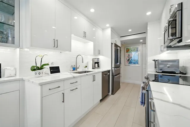 a kitchen with cabinets appliances a sink and a counter top space