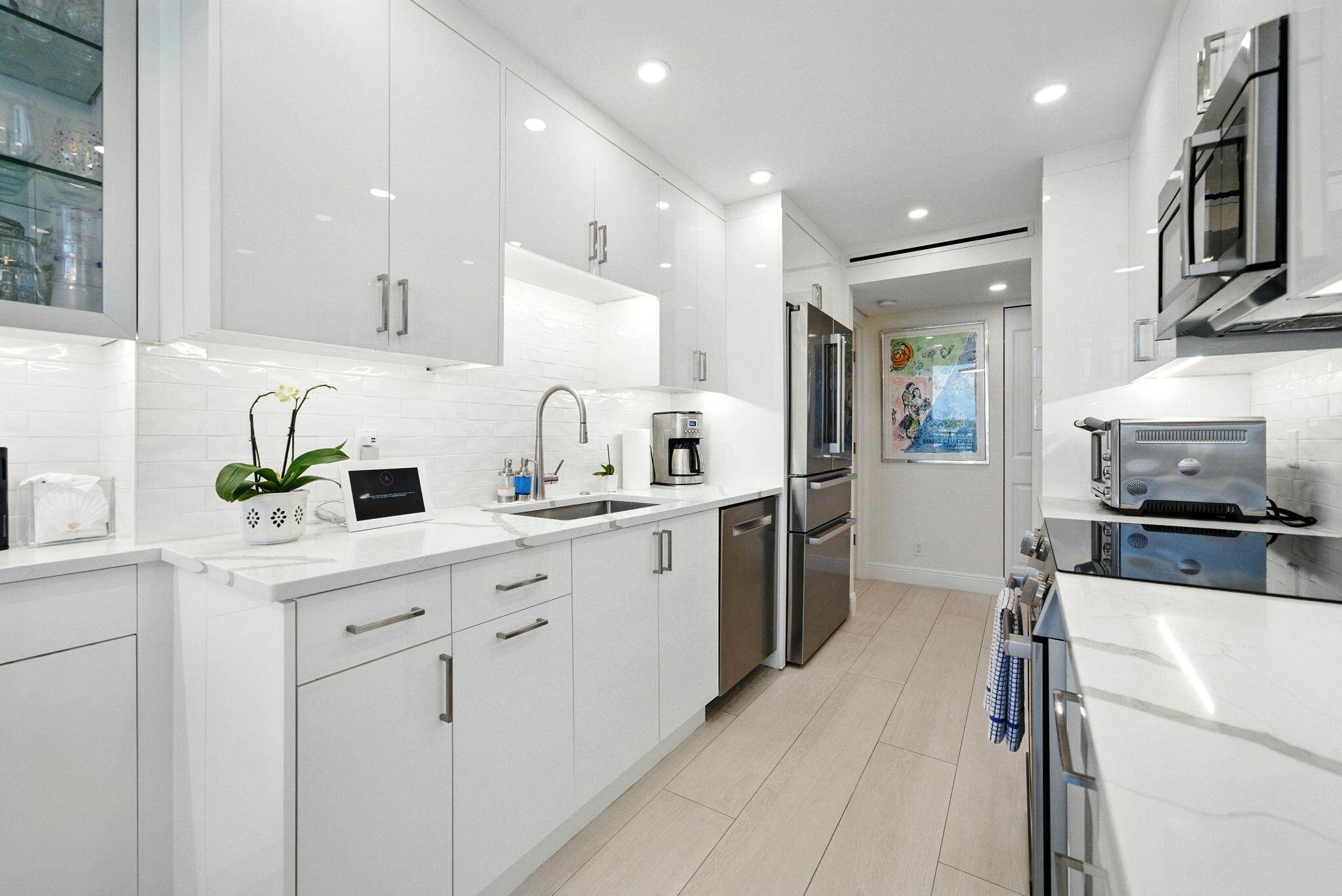 1801 South Flagler Drive, Unit 709 West Palm Beach, FL 33401 - Photo 9 of 39 a kitchen with cabinets appliances a sink and a counter top space