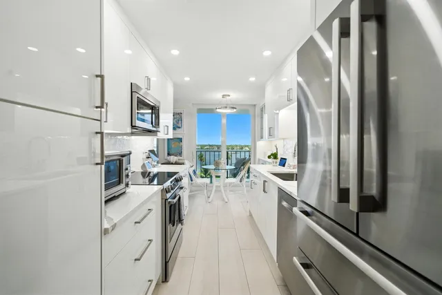 a kitchen with stainless steel appliances a sink a stove a refrigerator and cabinets