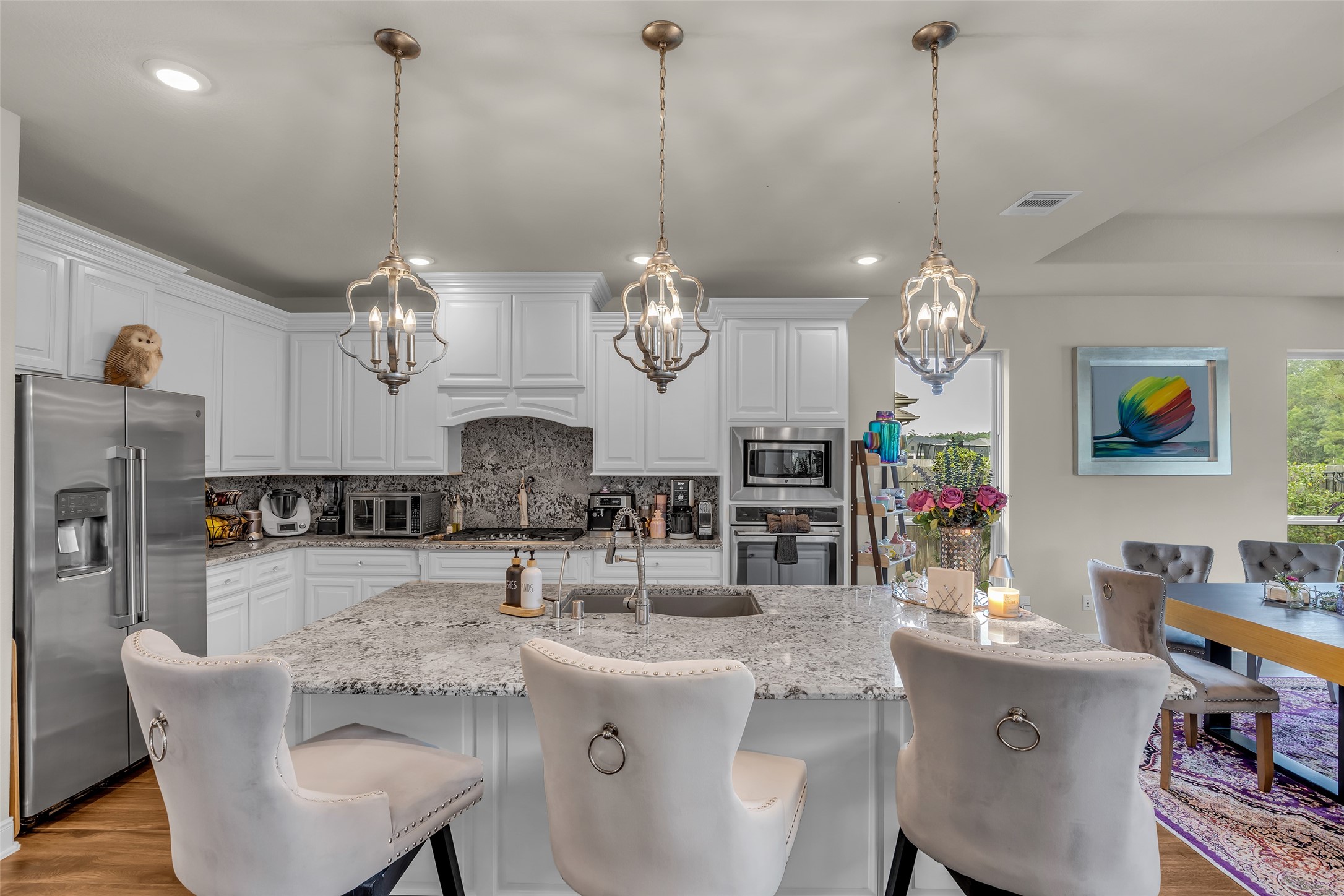 7211 Julie Pond Lane Spring, TX 77389 - Photo 16 of 45 Experience elegance in this modern kitchen featuring a spacious island with granite countertops, chic pendant lighting, and sleek stainless steel appliances. Perfect for entertaining and culinary creativity.