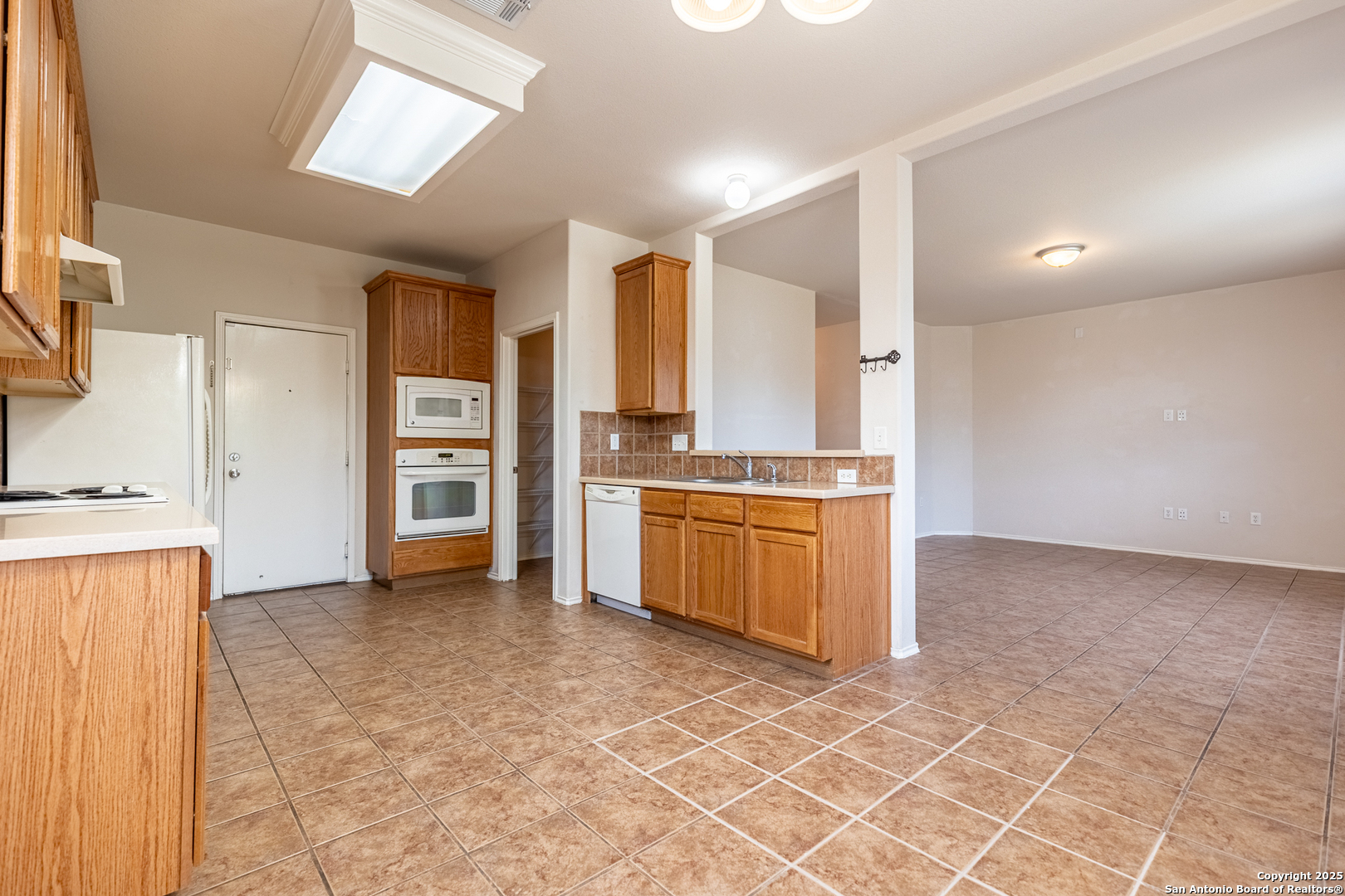 1134 Seven Iron Way San Antonio, TX 78221 - Photo 11 of 33 a kitchen with stainless steel appliances a stove a sink and a refrigerator
