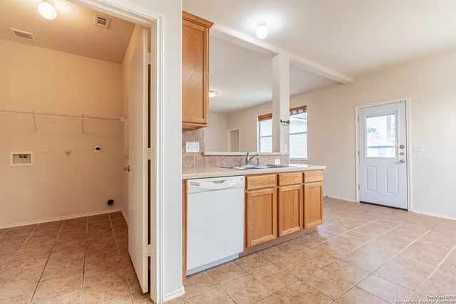 a kitchen with granite countertop cabinets sink and a window