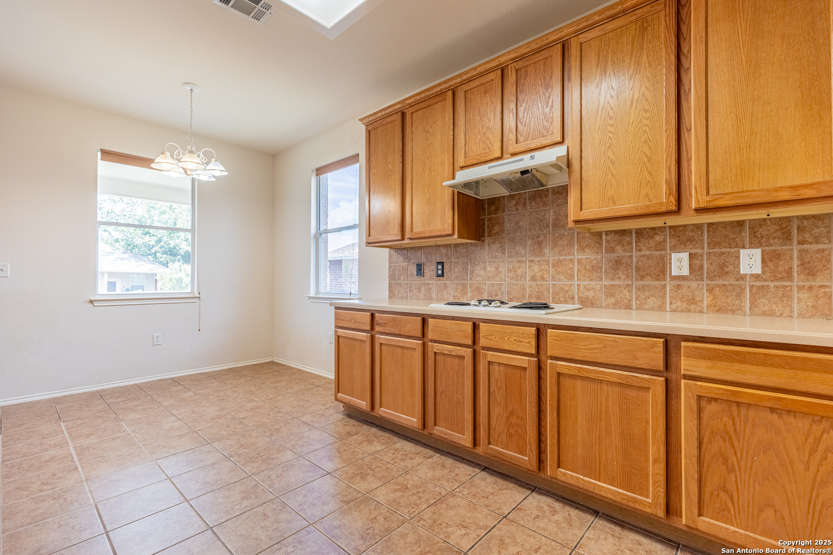 1134 Seven Iron Way San Antonio, TX 78221 - Photo 14 of 33 a kitchen with granite countertop cabinets sink and a window