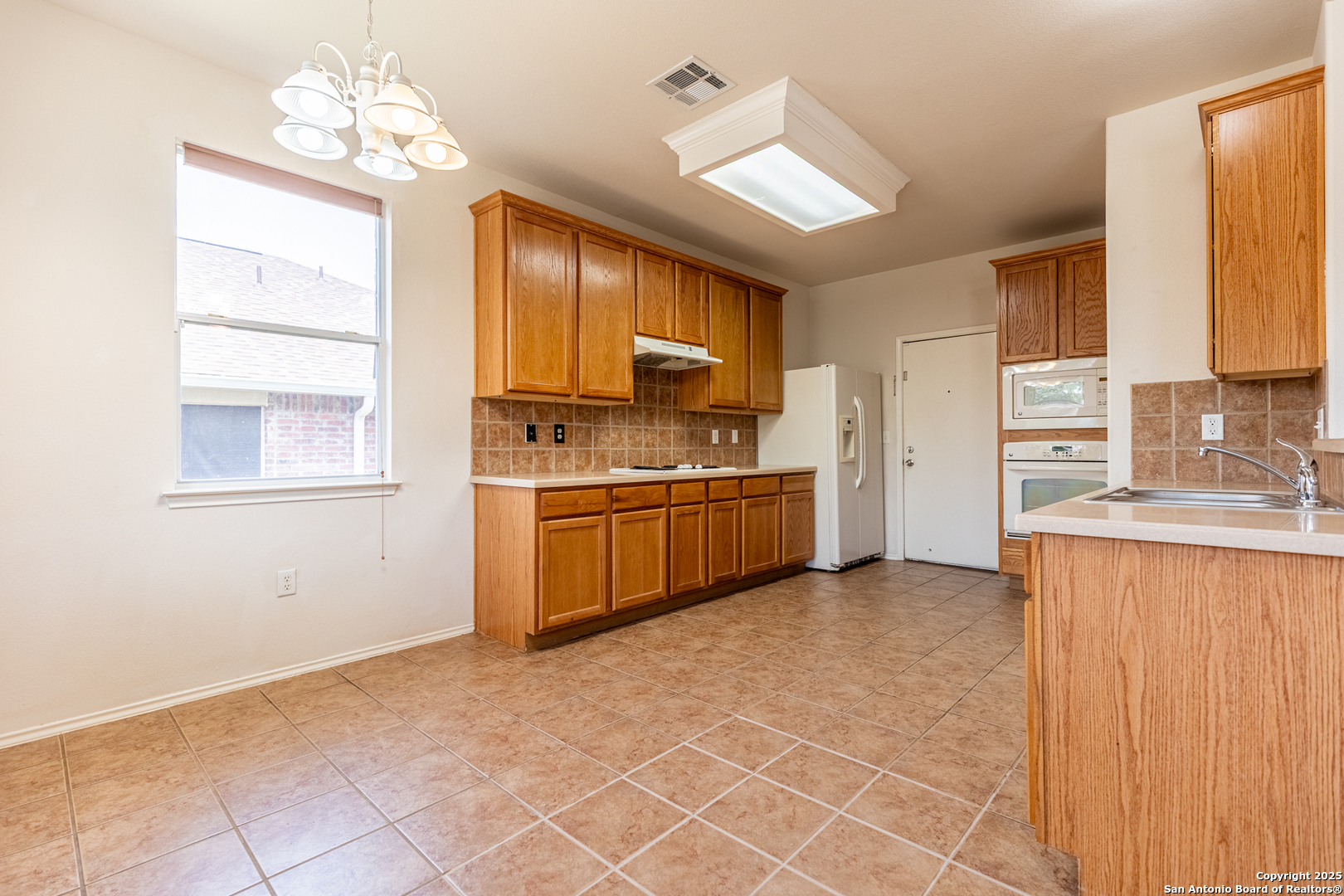 1134 Seven Iron Way San Antonio, TX 78221 - Photo 10 of 33 a kitchen with stainless steel appliances granite countertop a stove a sink and a refrigerator