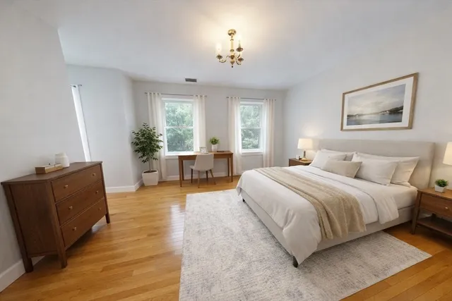 a spacious bedroom with a large bed and wooden floor