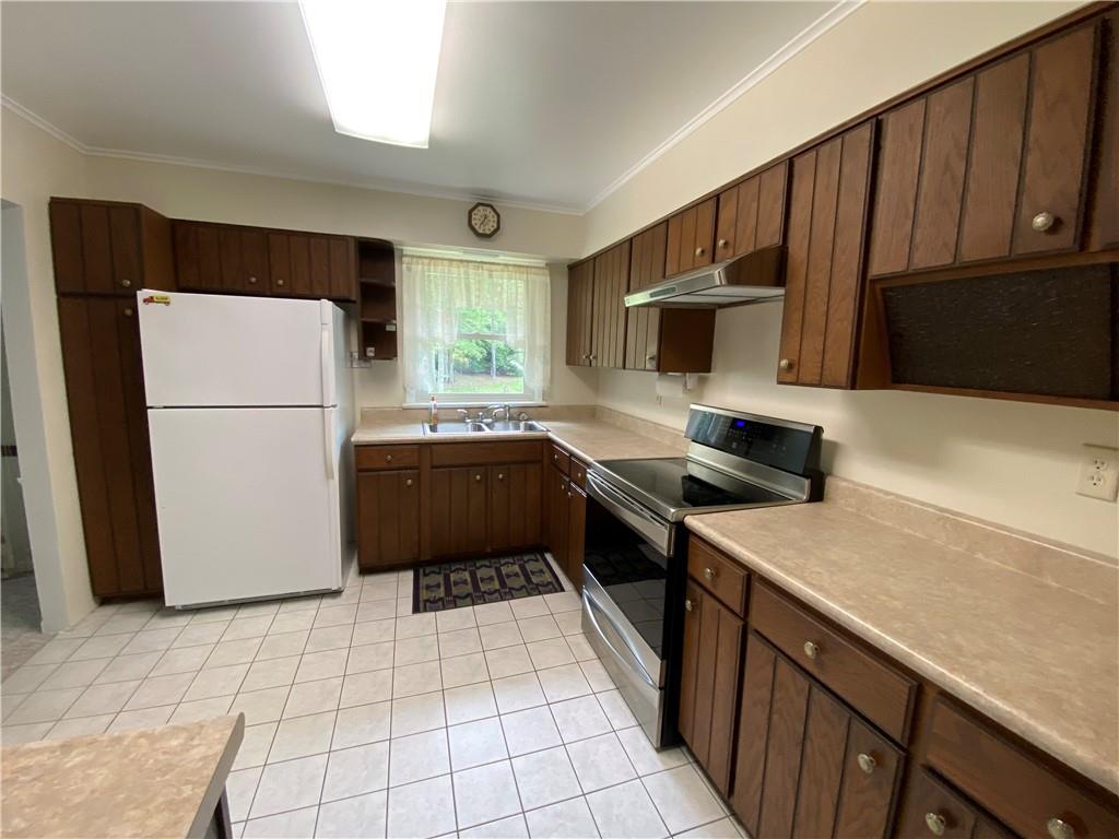 262 Thorne Run Road Export, PA 15632 - Photo 13 of 19 a kitchen with a refrigerator a stove a sink dishwasher and wooden cabinets with wooden floor