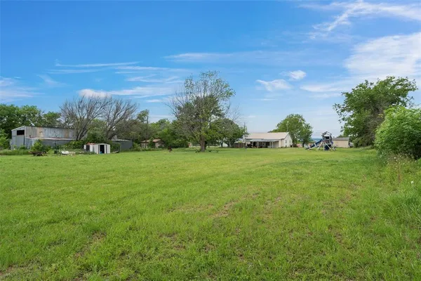 a view of yard with grass & street