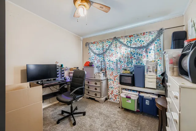 a view of a workspace with furniture and a window